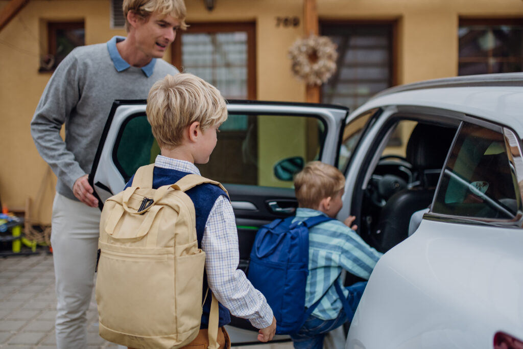 Parent getting children into the car for back-to-school driving in Essex Ontario